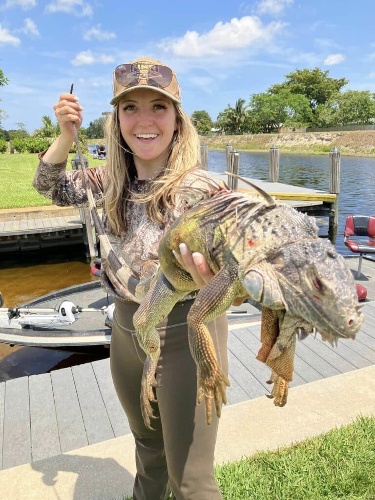 lady holding up catch from iguana hunting florida