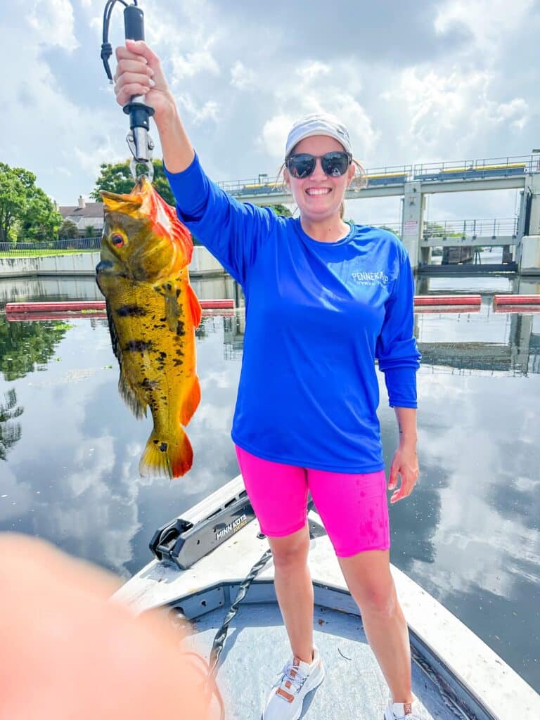 proud girl showing her peacock bass in florida